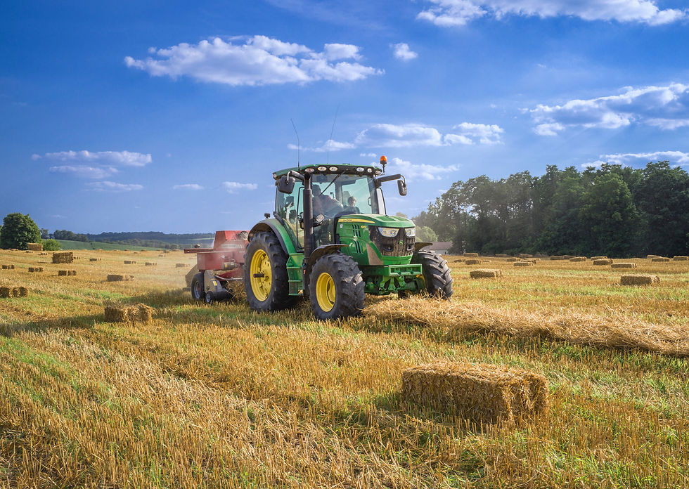 Tracteur vert produisant des bottes de paille.