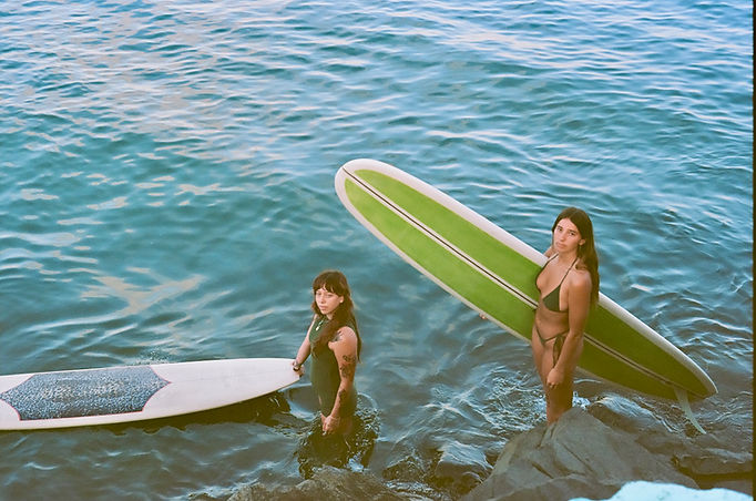 Sunset over two surfers in beautiful ocean