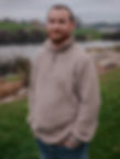 Ashley in a sweater with a lake and hills in the background.