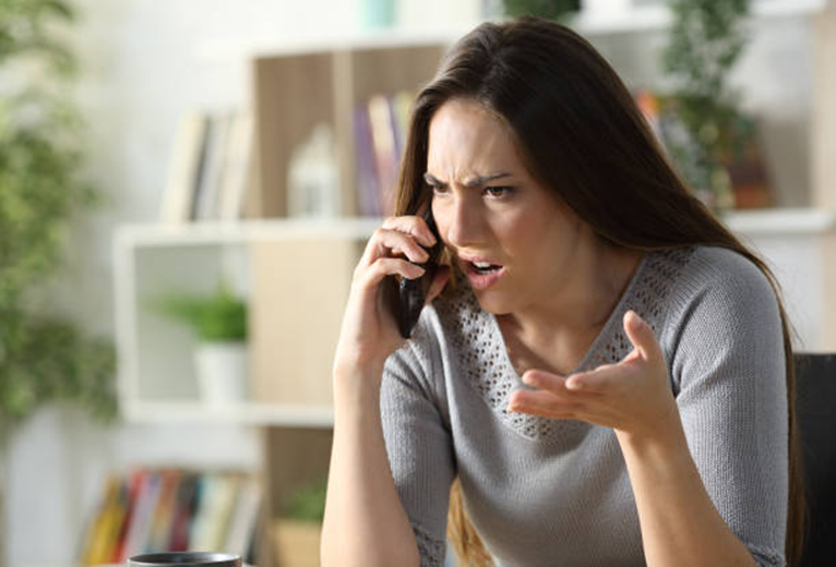 Woman on the phone, seemingly upset with the person she is talking to.