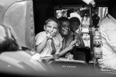 Three smiling boys making peace signs