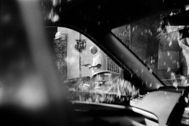 Man holding tray viewed through car window