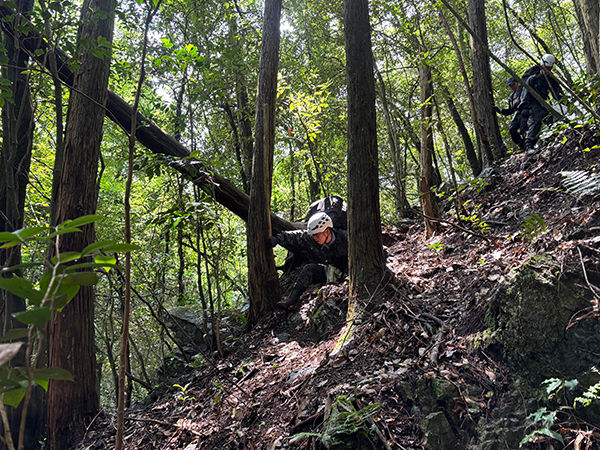 急斜面の山道で滑り落ちながらも必死で立ち上がる。約40キロのザックを背負って行う訓練の厳しさを目の当たりにした（7月15日）