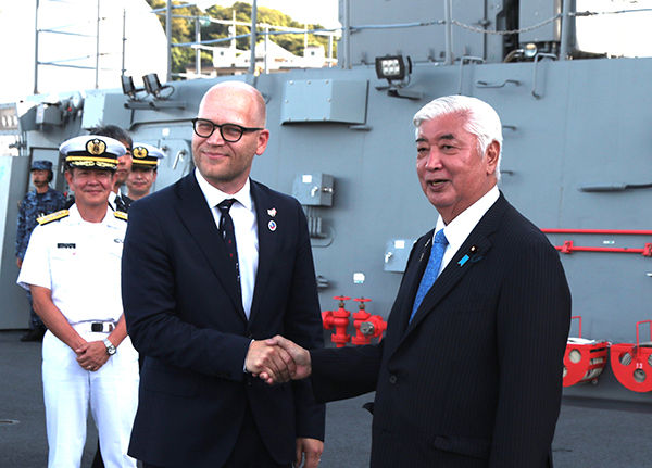 護衛艦「かが」の艦上で握手を交わす中谷防衛相(右)とノルウェーのフロム国防副大臣(8月23日、神奈川県横須賀市)