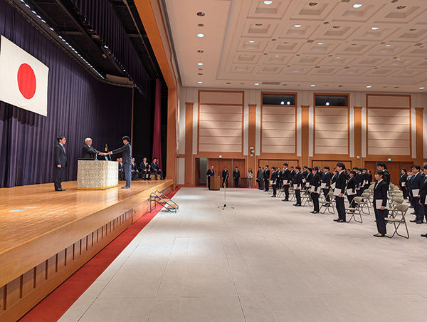 入省式で壇上の中谷防衛相から辞令を交付される石神慎也事務官（4月1日、防衛省講堂）