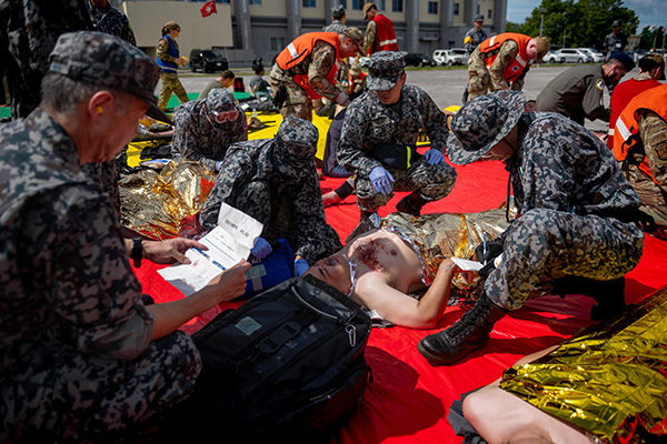 大規模負傷者対応訓練で模擬負傷者を処置する日米の衛生隊員ら（7月22日、三沢基地）＝いずれも米空軍HPから