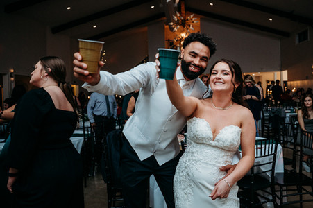 Bride and groom toasting the camera at wedding reception