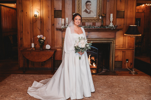 full length portrait of a bride in front of fire place at Cascades Manor