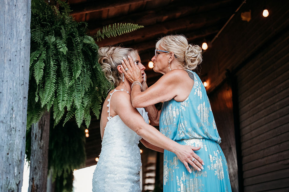 bride with mom's hands on her face 