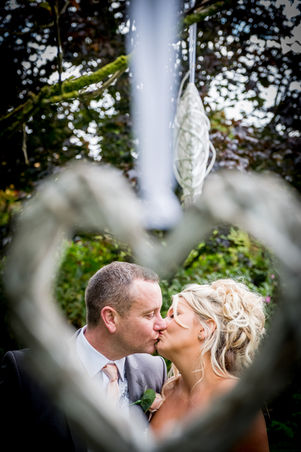 Bride and groom kissing framed by a heart at Parley Manor