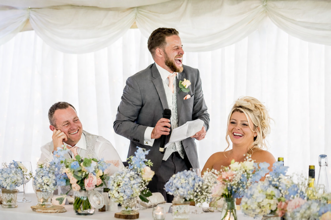 Bride and groom laughing during the best man’s speech at Parley Manor wedding