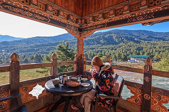 Chumey Village in Bumthang with traditional Bhutanese homes surrounded by lush fields and rolling hills