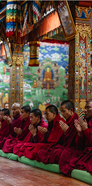 Buddhist monk receiving blessings from a senior lama in a traditional Bhutanese monastery setting