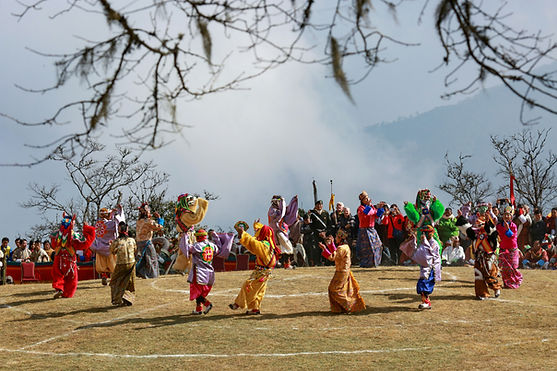 Masked dancers in vibrant costumes performing sacred dances during Dochula Druk Wangyel Tshechu festival in Bhutan.