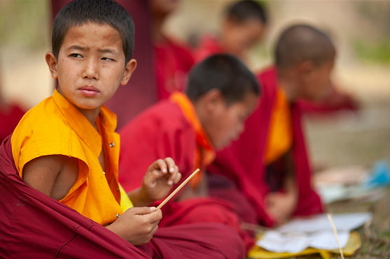 Young Buddhist monk studying scriptures inside a peaceful Bhutanese monastery
