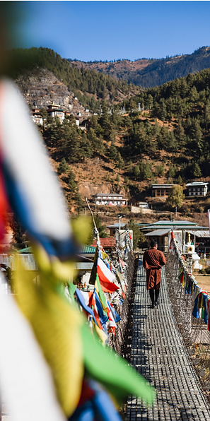 Punakha Suspension Bridge spanning the Mo Chhu River, surrounded by lush green valleys and traditional Bhutanese scenery