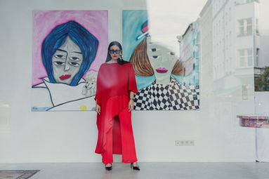 Artist Kristina Supernova photographed at the gallery in Berlin in front of her work.
