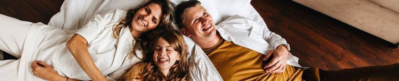 Happy family lying on clean floor and enjoying the freshness after One - Time Cleaning service