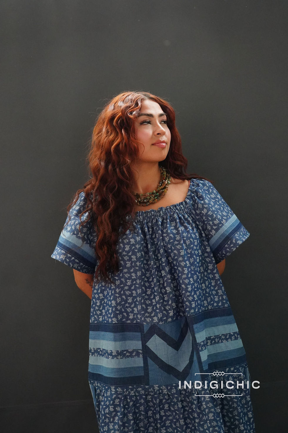 a woman with red hair is wearing a blue dress