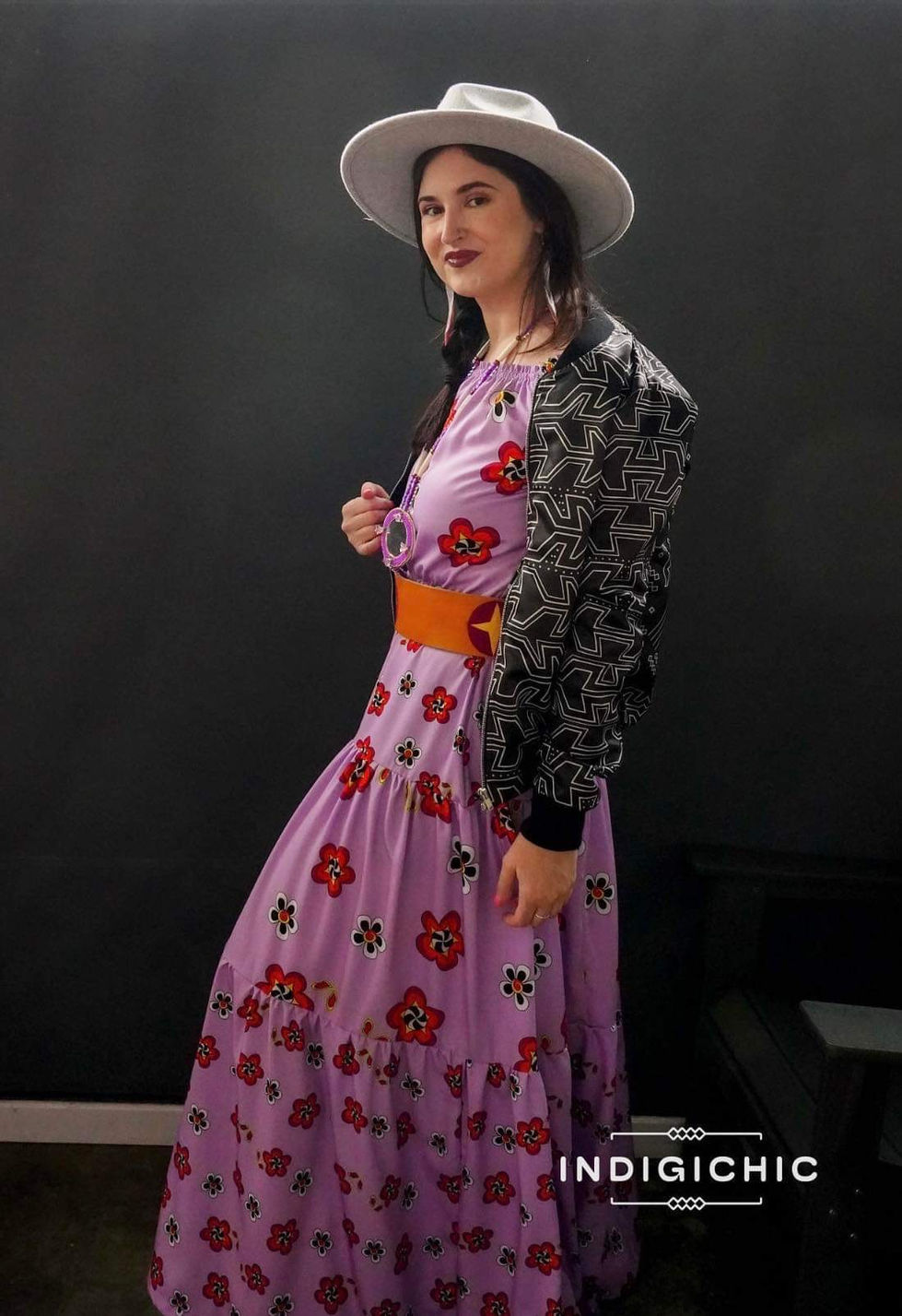 a woman wearing a purple dress with flowers on it