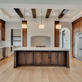 Modern kitchen by Murray Custom Homes designed with wood cabinets, light flooring, island, and stainless appliances.