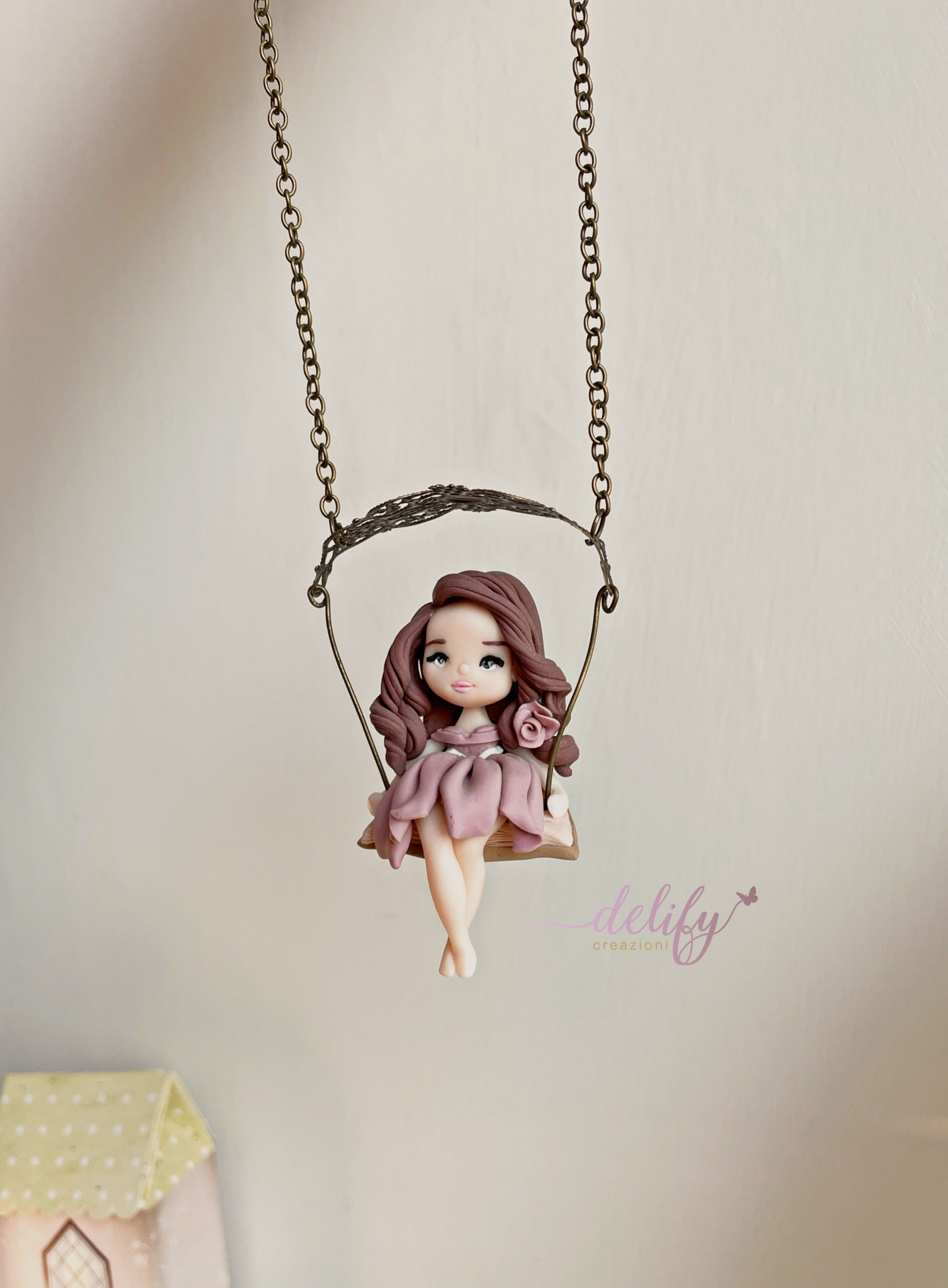 Collana con Bambolina seduta su libro con Altalena