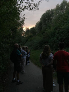 Group photo of people looking for bats in the park at dawn.