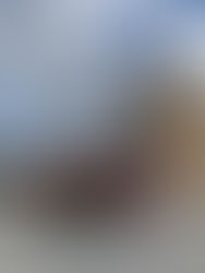 A fire engine with an extended aerial ladder raised high beside a training building, with firefighters standing on the platform.