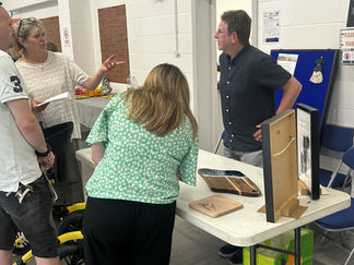 People talking around a stall and looking at promotional materials.