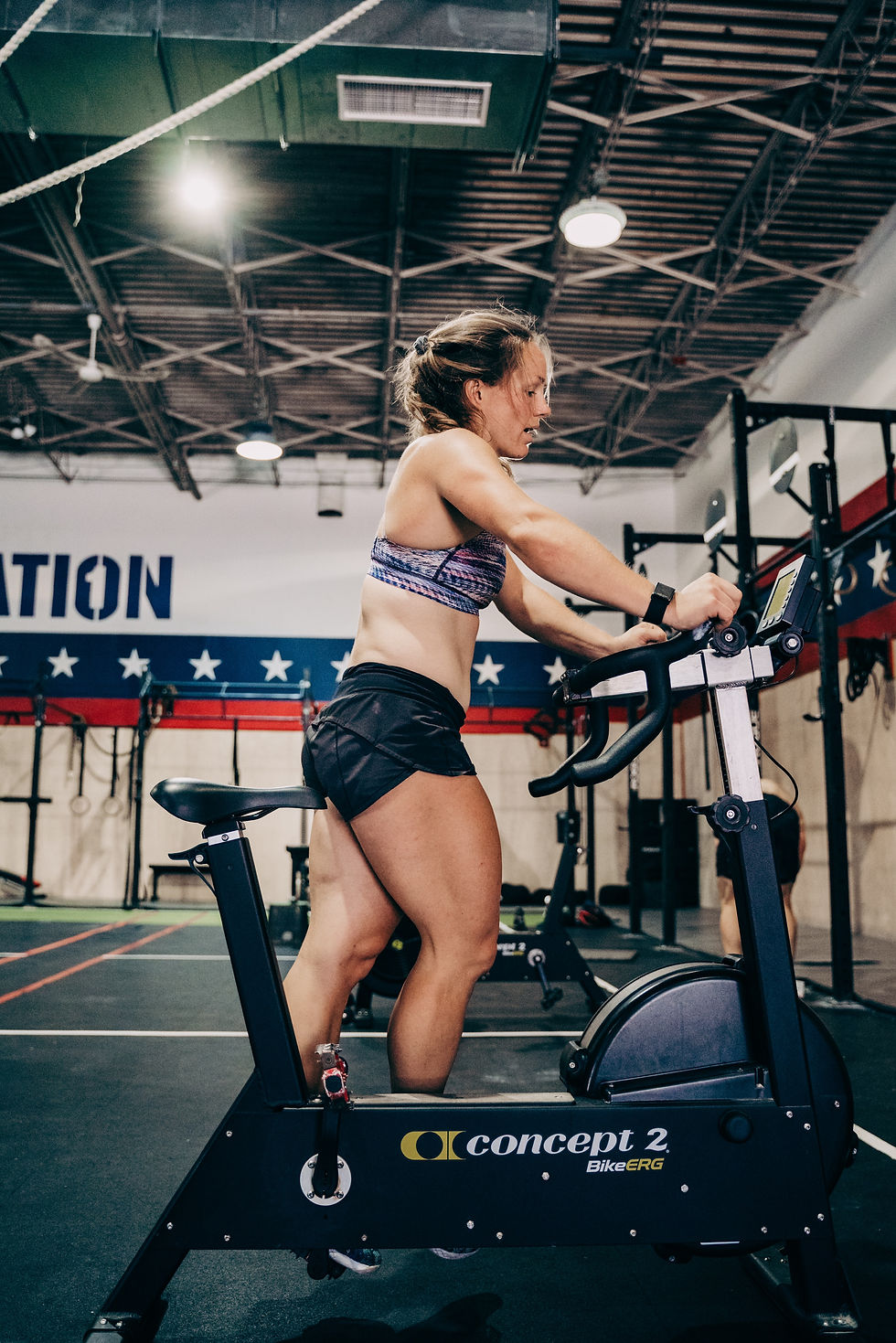 Coach Nicole resetting a Concept 2 bike mid workout.