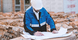 construction supervisor reviewing plans on site under schedule pressure before excavation