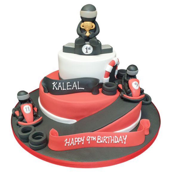 A fun and creative go-karting themed cake featuring a detailed edible replica of a racing track, karts, and flags on top. Perfect for a racing enthusiast's celebration.