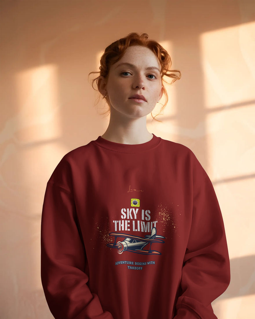Woman wearing a red sweatshirt with the text 'SKY IS THE LIMIT' illustration.