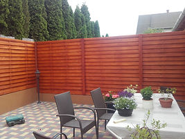 Vörös fa kerítéslapok terasz mellett – természetes hatású, hőkezelt fa kerítés Fa-Land.