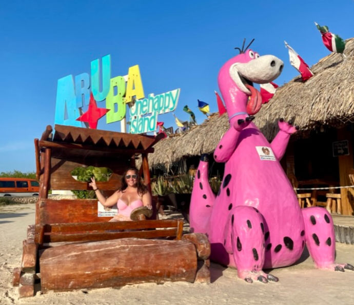 Girl at beach with giant pink dino