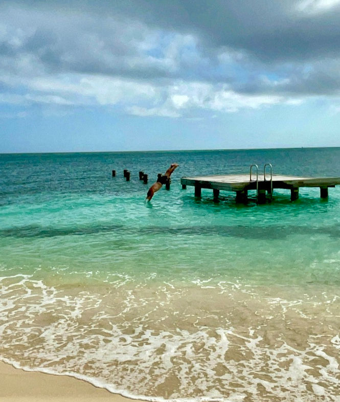 cloudy sky with grown man jumpin in the water