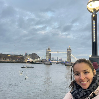 girl smiling with bridge behind her 