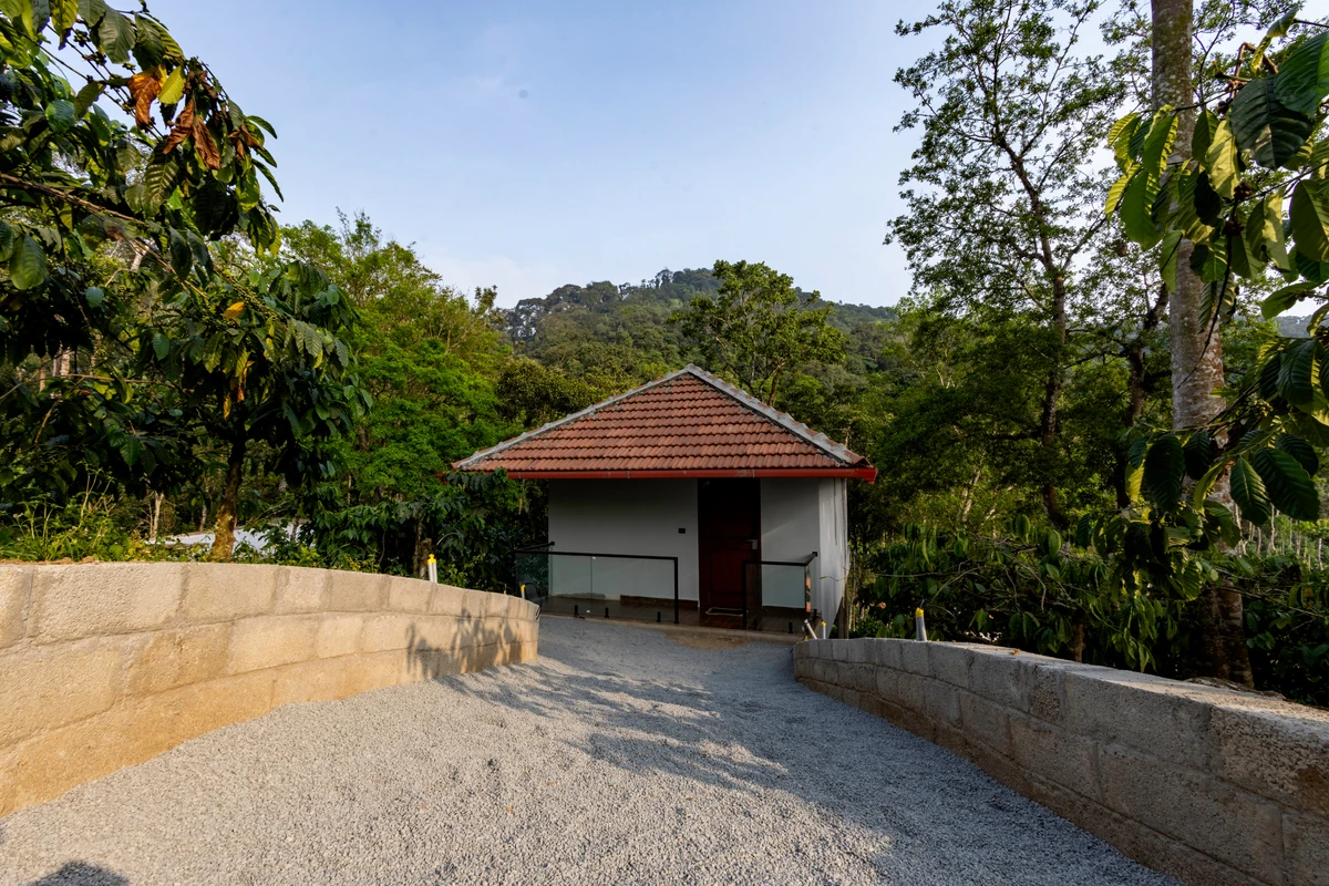 Cottage at the end of a gravel path between stone walls