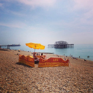 Brighton life guards with yellow umbrella burnt old air in the background