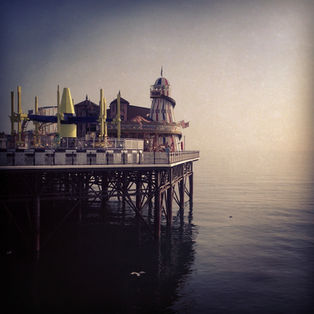 photo du pier de Brighton on voit bien les attraction et le vol d'un goéland qui rase l'eau