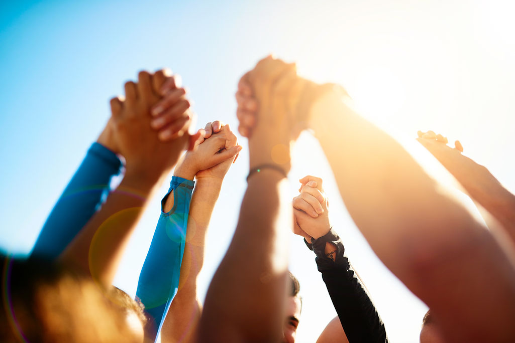 Lets stand together. Shot of a group of unrecognizable people holding hands together in th