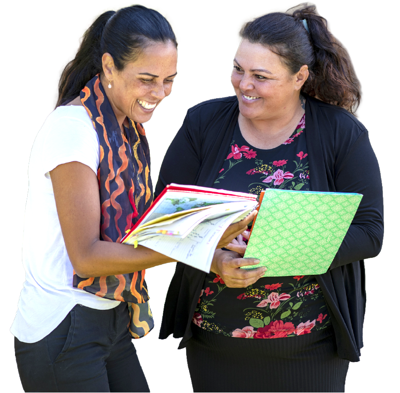 Two smiling women sharing a folder of documents, reflecting collaboration and culturally inclusive women's health support.
