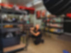Videographer setting up camera on tripod for a product shoot inside a retail store