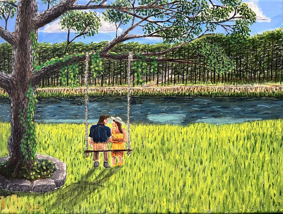 A couple happily sits on a swing suspended by a tree, overlooking a river flowing past. On the other side of the river sits a forest.