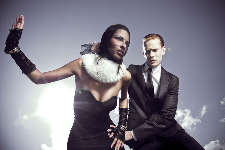 weibliches Model im schwarzen Kleid posiert mit einem männlichen Model im schwarzen Anzug