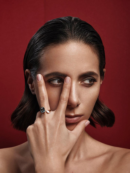 female model, beauty shot making V with her fingers, wearing a ring