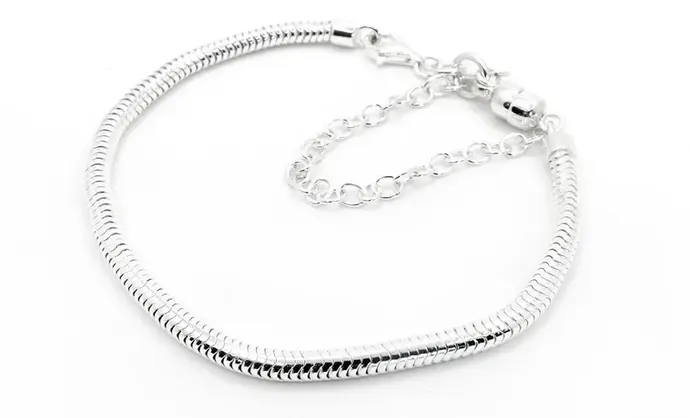 A sterling silver charm bracelet with a magnetic safety chain is shown on a white background. It fastens with a lobster clasp.