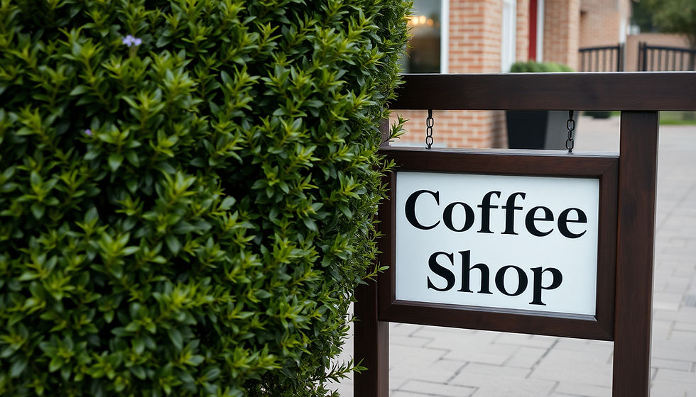 Close-up view of a local business sign surrounded by greenery