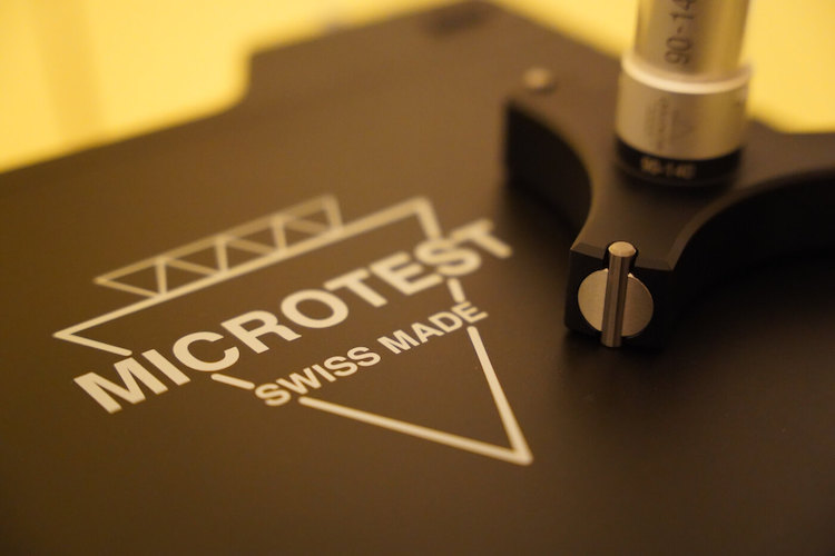 Microtest AG Banner zeigt Koffer mit Logo und eine analoge Innenmessschraube