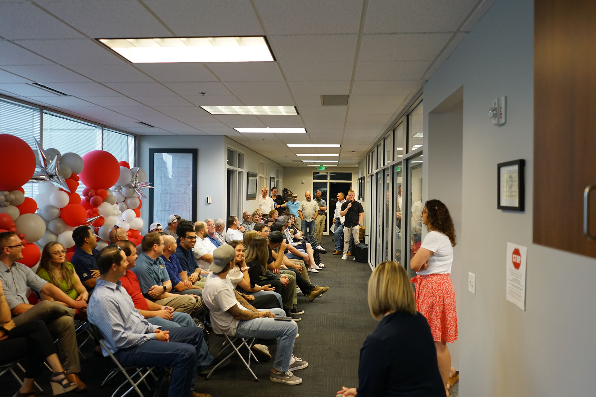 CRS Employees sitting in office with red & white balloons.